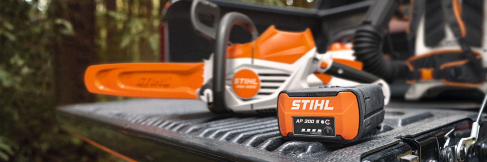 Kettensäge mit Akku von Stihl liegt auf der Ladefläche eines Autos.